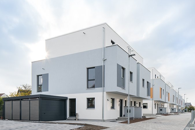 FingerHaus Projekt KarbenPUR: Neubaugebiet in Karben mit modernen weißen Doppelhäusern und Garagen.