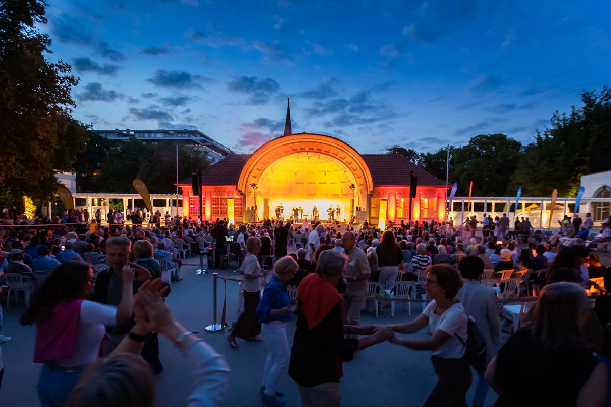 Open-Air-Konzert in Bad Nauheim mit beleuchteter Bühne, zahlreichen Zuschauern und tanzenden Menschen am Abend.